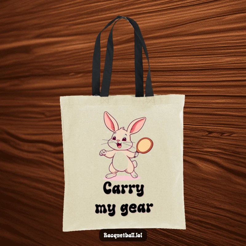 Funny bunny swinging a tiny racquetball paddle on a tote bag. A sporty funny gift for shoppers.